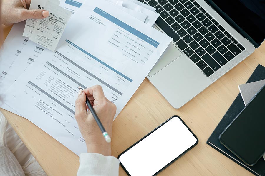 Documentos financieros, teléfono y portátil utilizados para revisar información de crédito